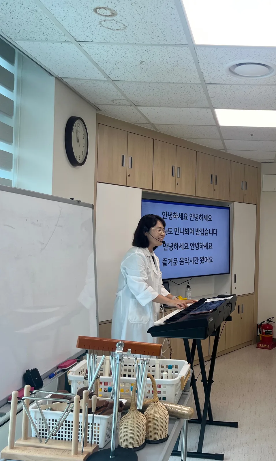 음악치료사가 키보드를 연주하며 그룹 음악치료를 진행하는 모습